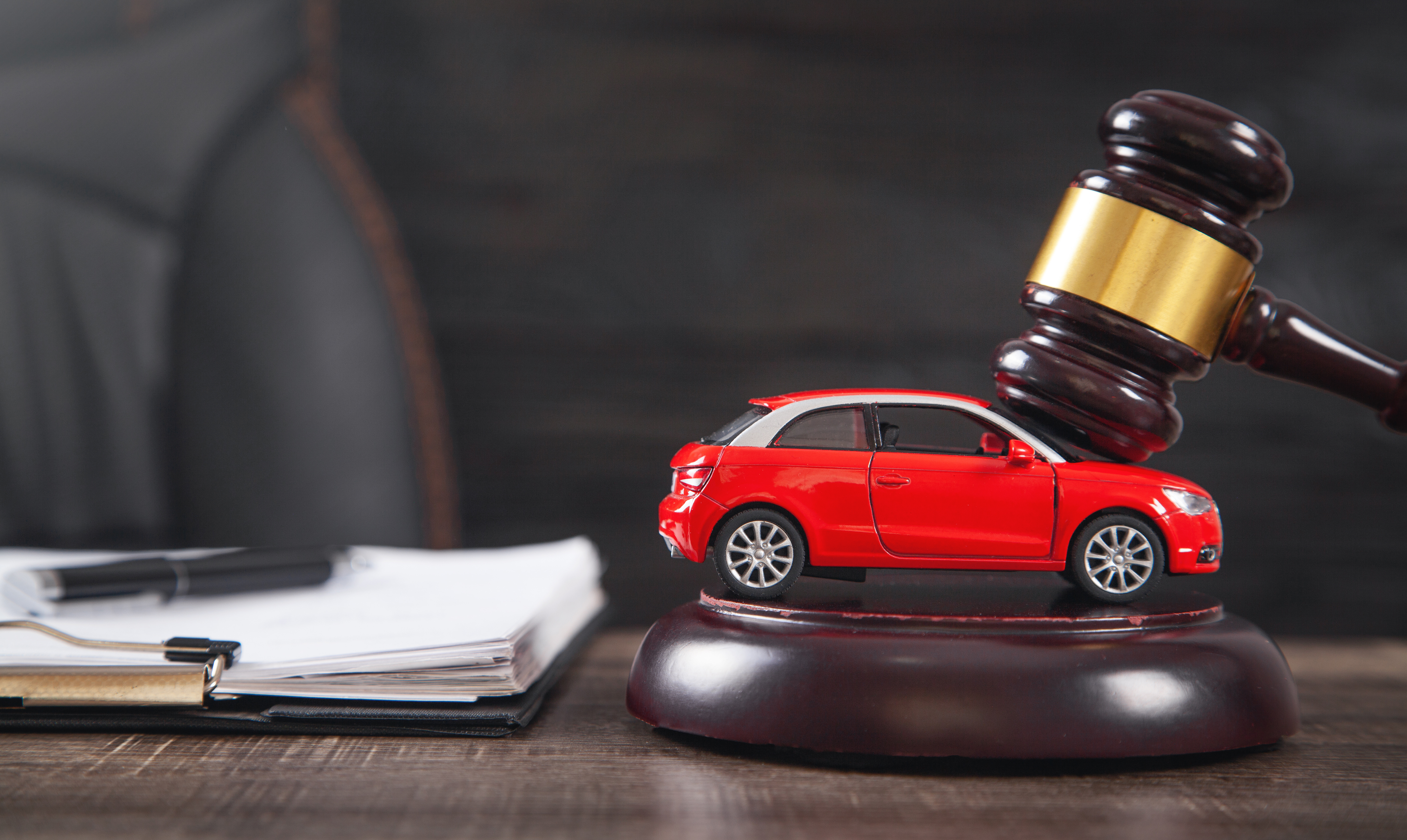 Red car model beside a judge's gavel representing automotive right to repair legislation